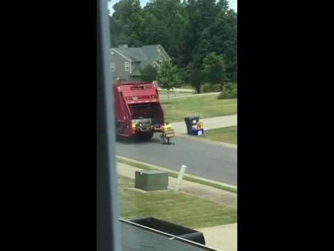 عامل نظافة يزحف خلف سيارة القمامة على كرسي