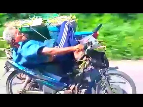 عجوز يقود دراجة بخاريَّة مستلقيًا على ظهره